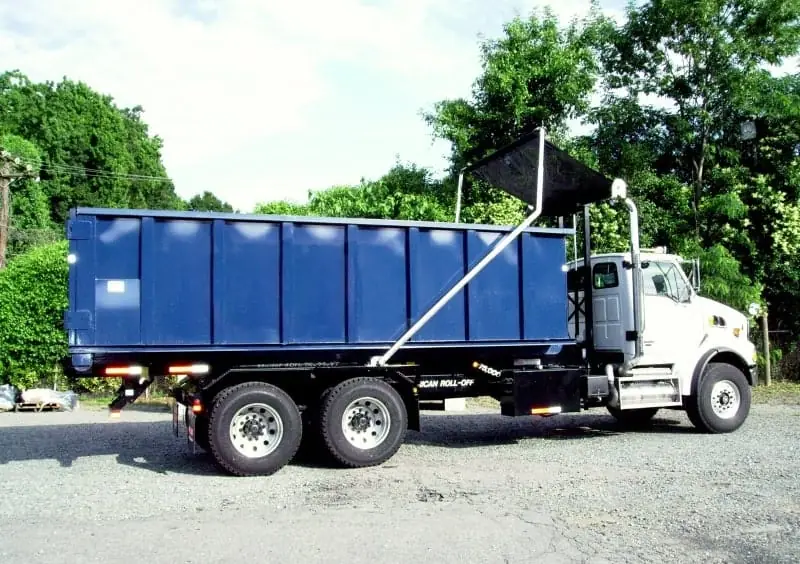 Roll-off truck hauling a dumpster